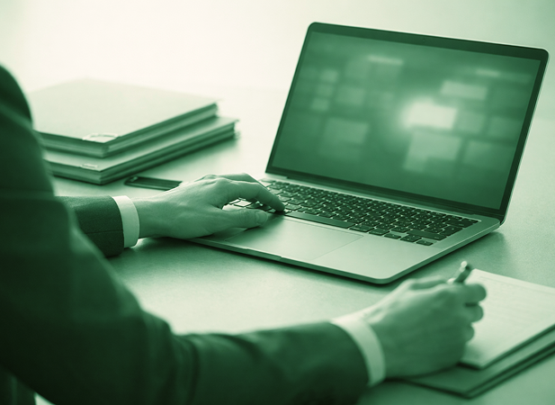 Cybersecurity professional working on a laptop at a desk
